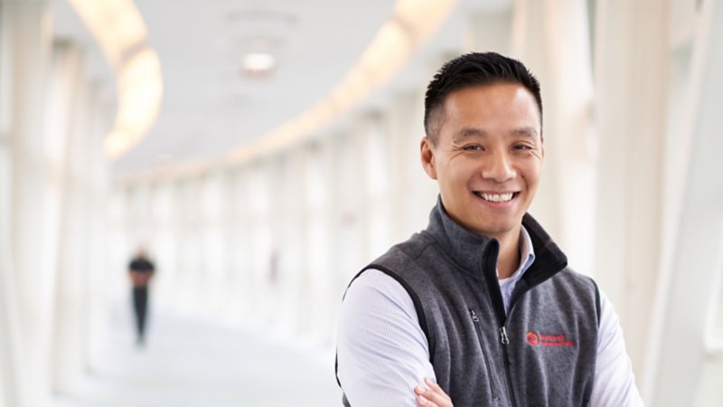 Rockwell Automation employee standing in long white hallway with arms crossed presenting himself as a trusted partner to collaborate with